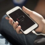 trzymany w ręku smartfon z ikoną ładowania baterii na ekranie